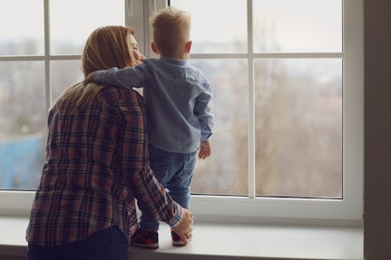 A mother and child looking out of a window