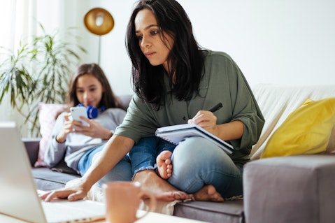 Woman at laptop making notes